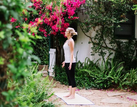 Woman standing strong with pink bougainvillea — personal empowerment course